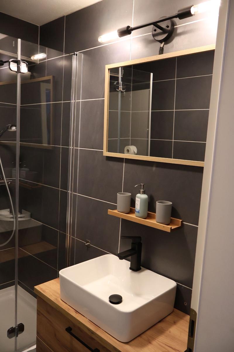 Badezimmer mit Dusche, Waschbecken und Spiegel