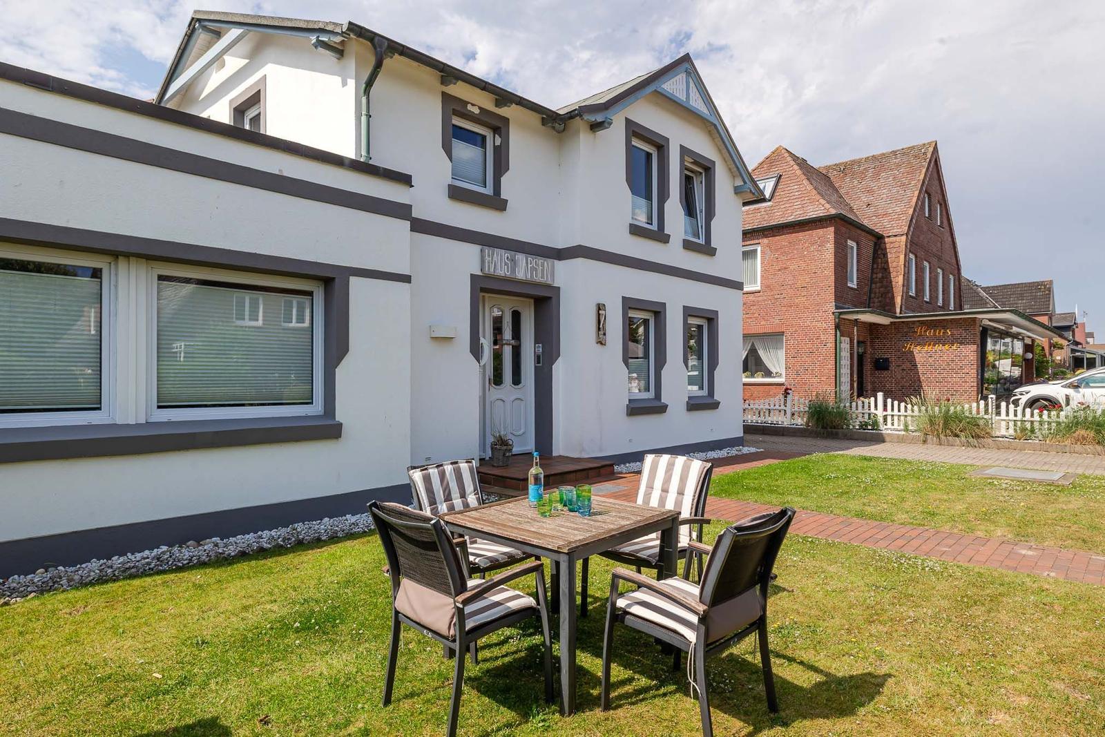 Haus Japsen mit Terrasse, Garten und Sitzgelegenheit. Hinterhof mit gepflastertem Weg.
