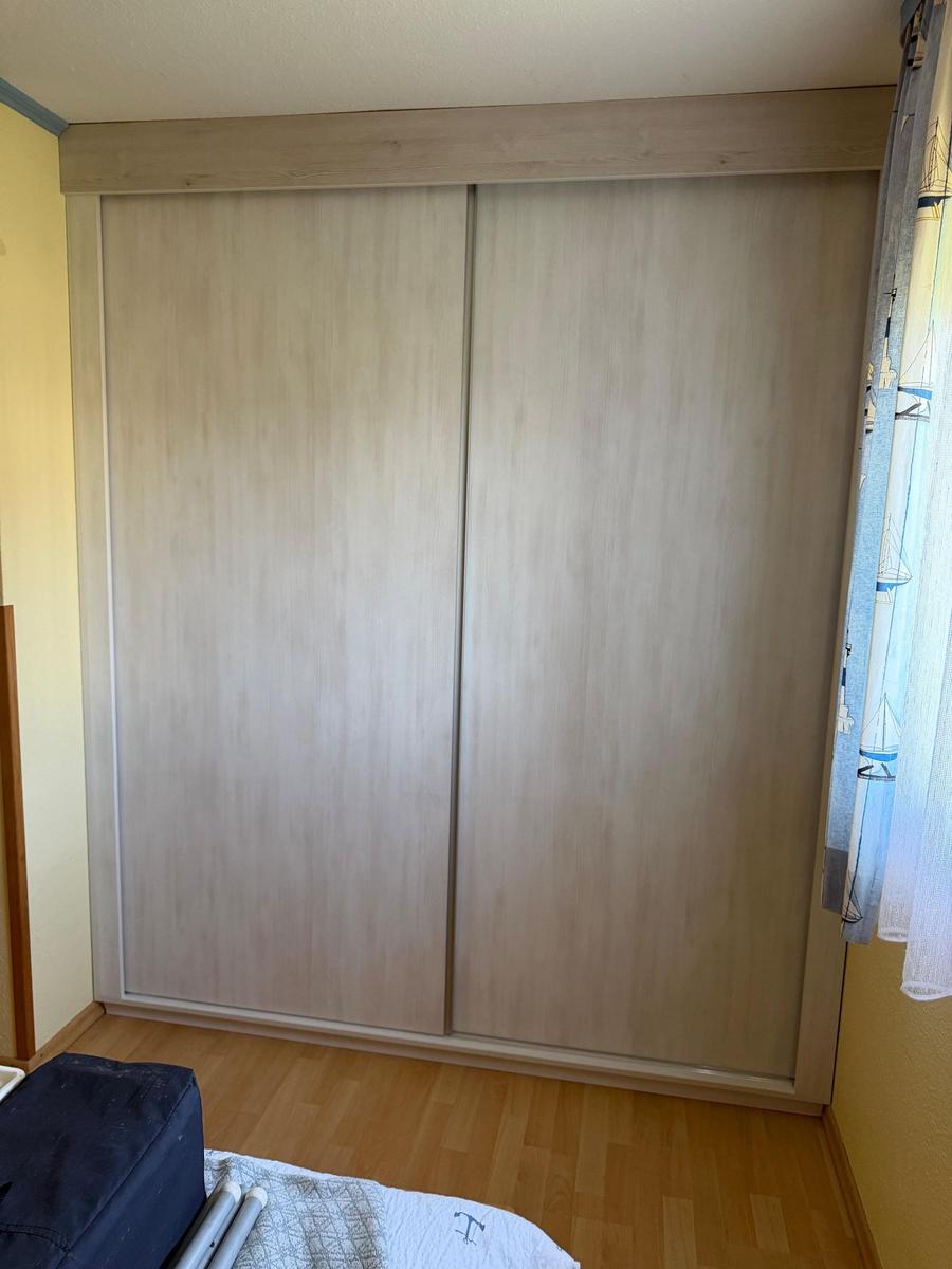 Schlafzimmer mit Schiebetürenschrank und Holzboden