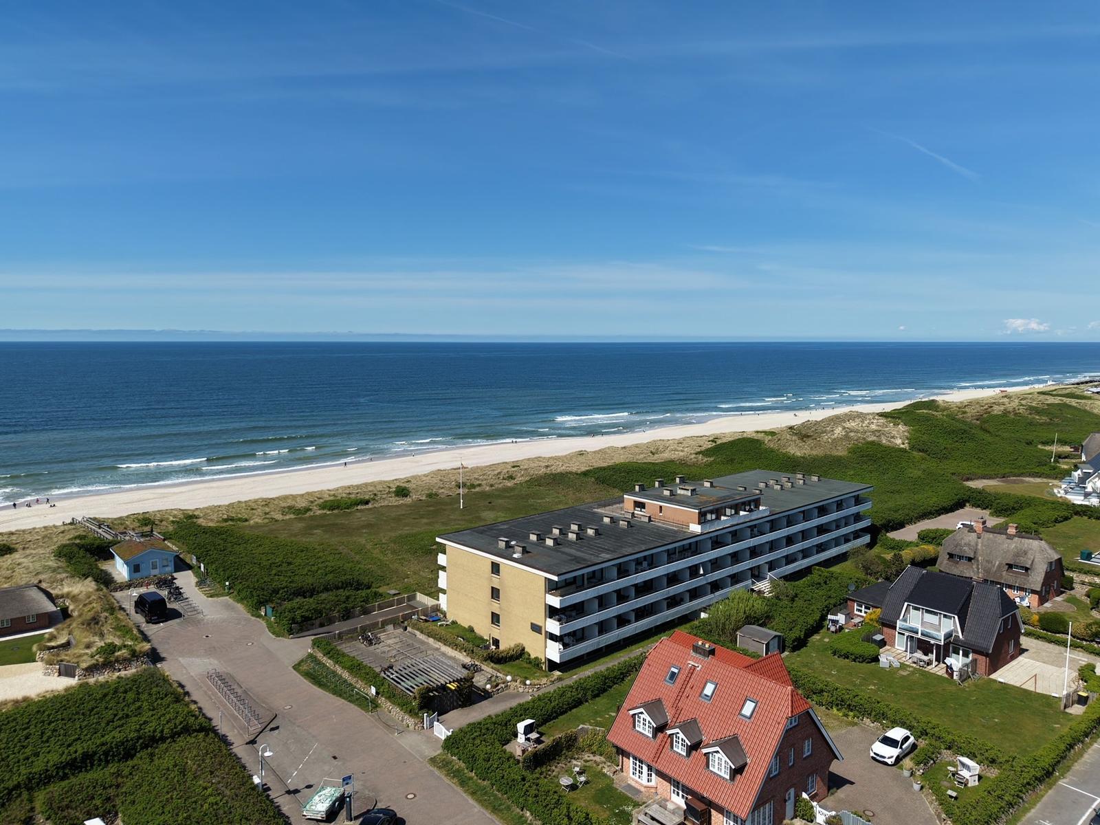 Strandnahe Ferienwohnung mit Blick aufs Meer und grüne Dünen.