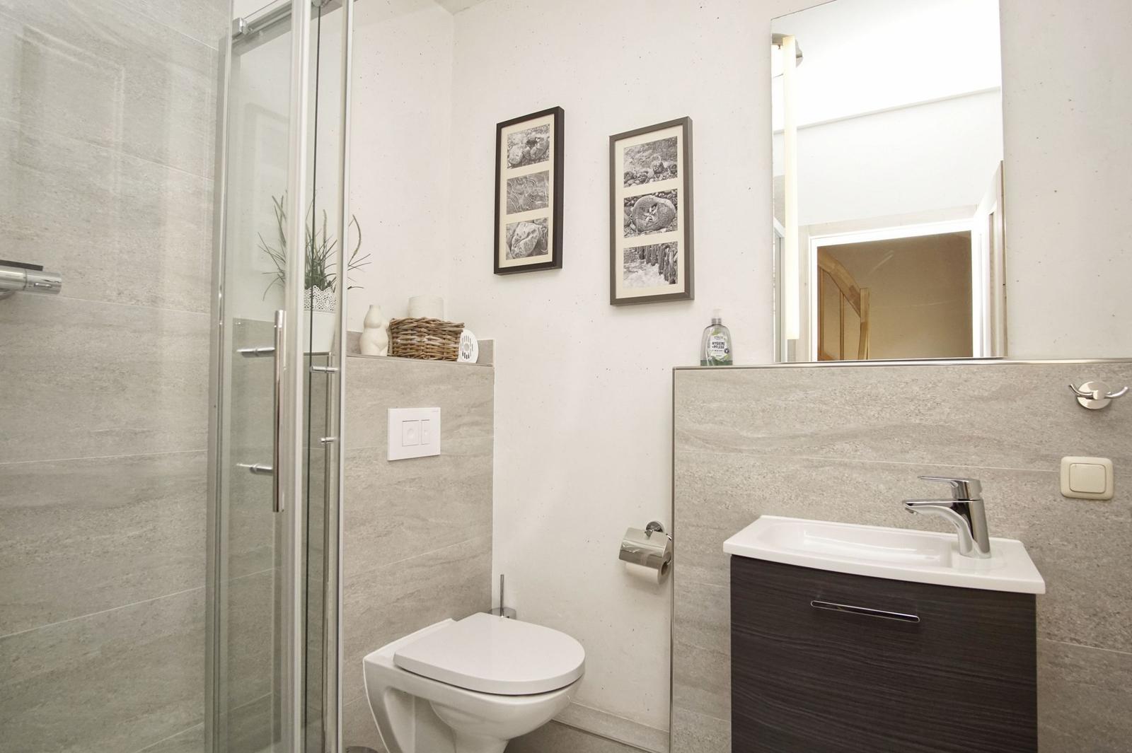 Badezimmer mit Dusche, Toilette und Waschbecken