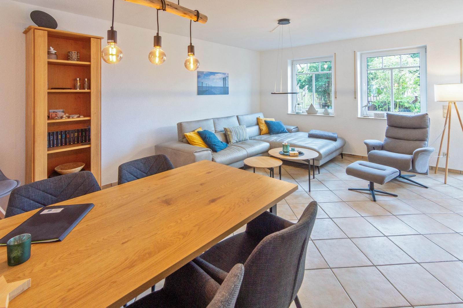 Wohn- und Essbereich mit Sofa, Sitzgruppe und Holztisch.