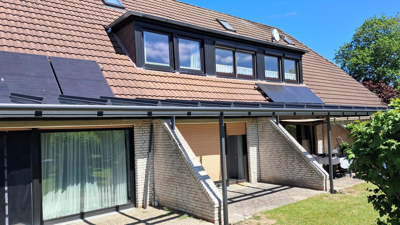 Haus mit Solaranlage, Dachfenstern und Terrasse im Grünen