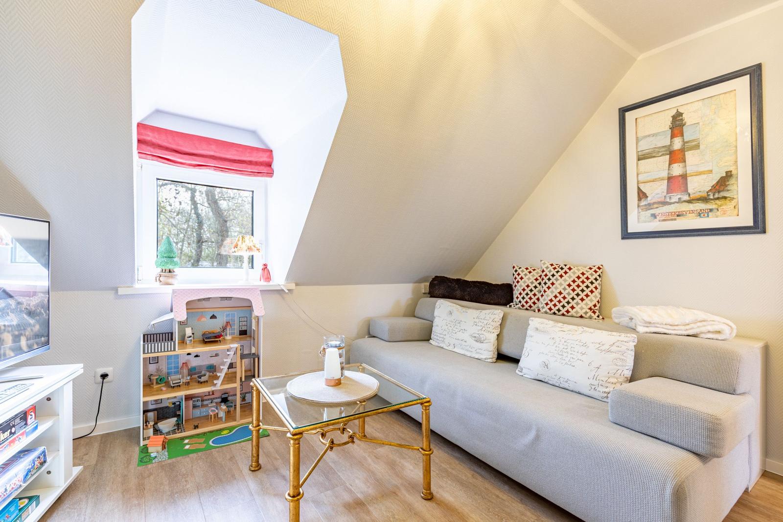 A living room with sofa, glass table, and window with red roller blind.