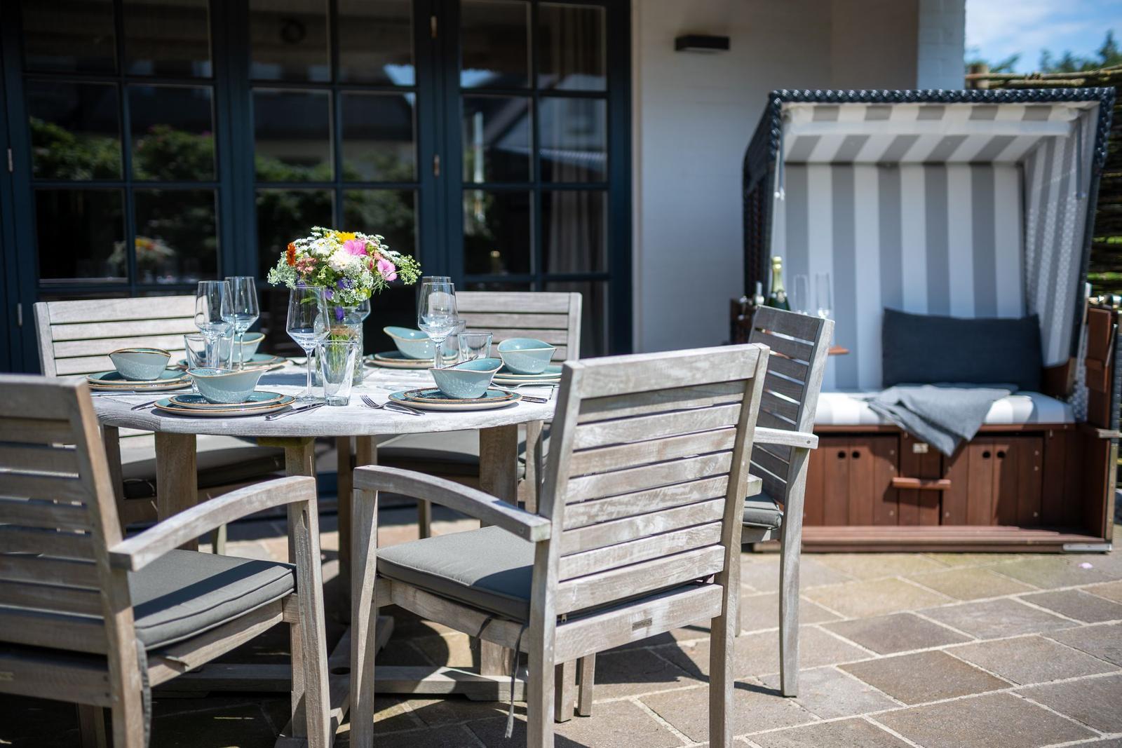 Outdoor area with set dining table and beach chair.