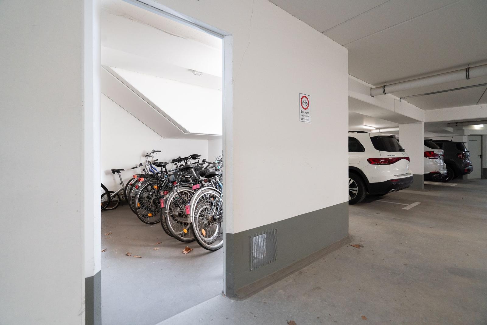 Tiefgarage mit Fahrradabstellraum und Parkplätzen für Autos.