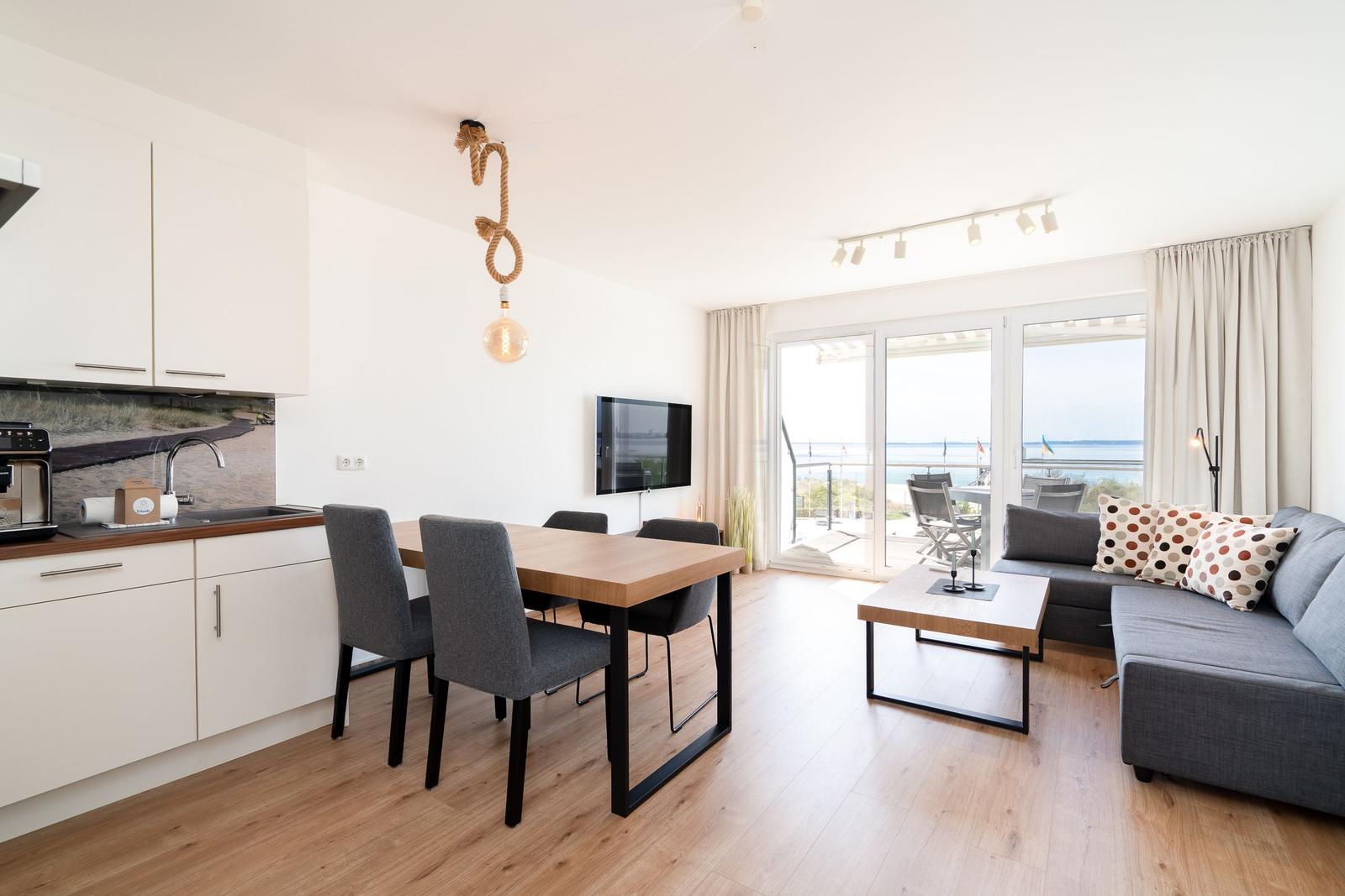 Wohnung mit Essbereich, Sofa und Blick auf die See
