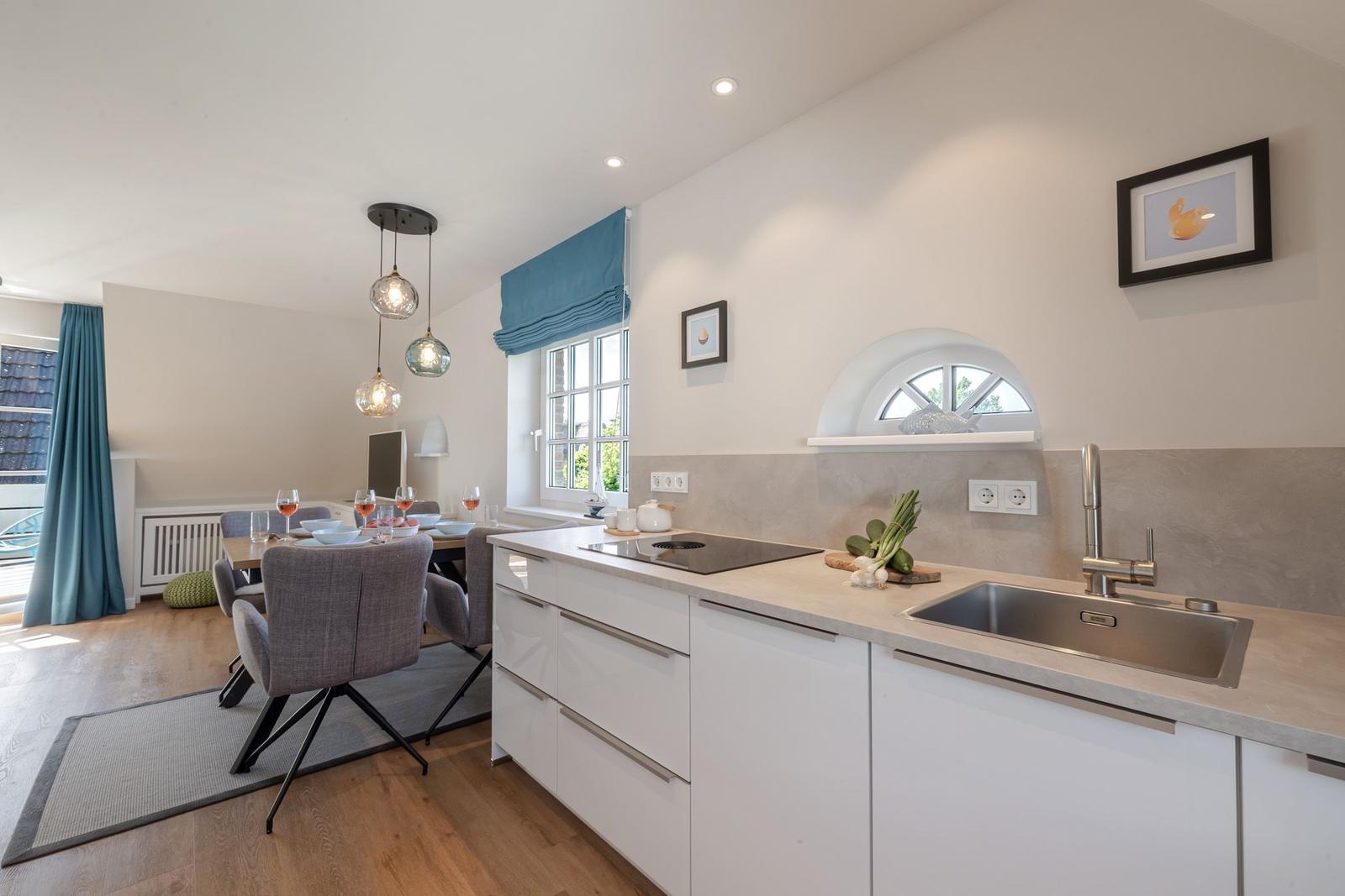 Kitchen with worktop, sink, and window. Dining area with table and chairs.