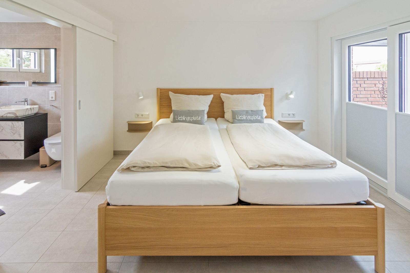 Schlafzimmer mit Doppelbett, Bad und Balkonanschluss.