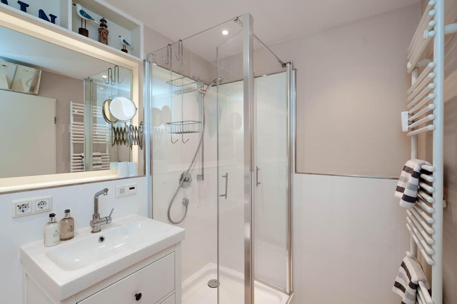 Bathroom with shower, sink, and heated towel rail