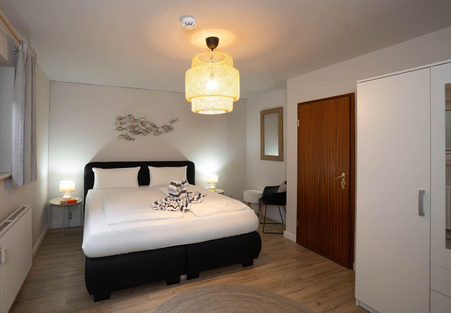 Schlafzimmer mit Bett, Lampe und Schrank