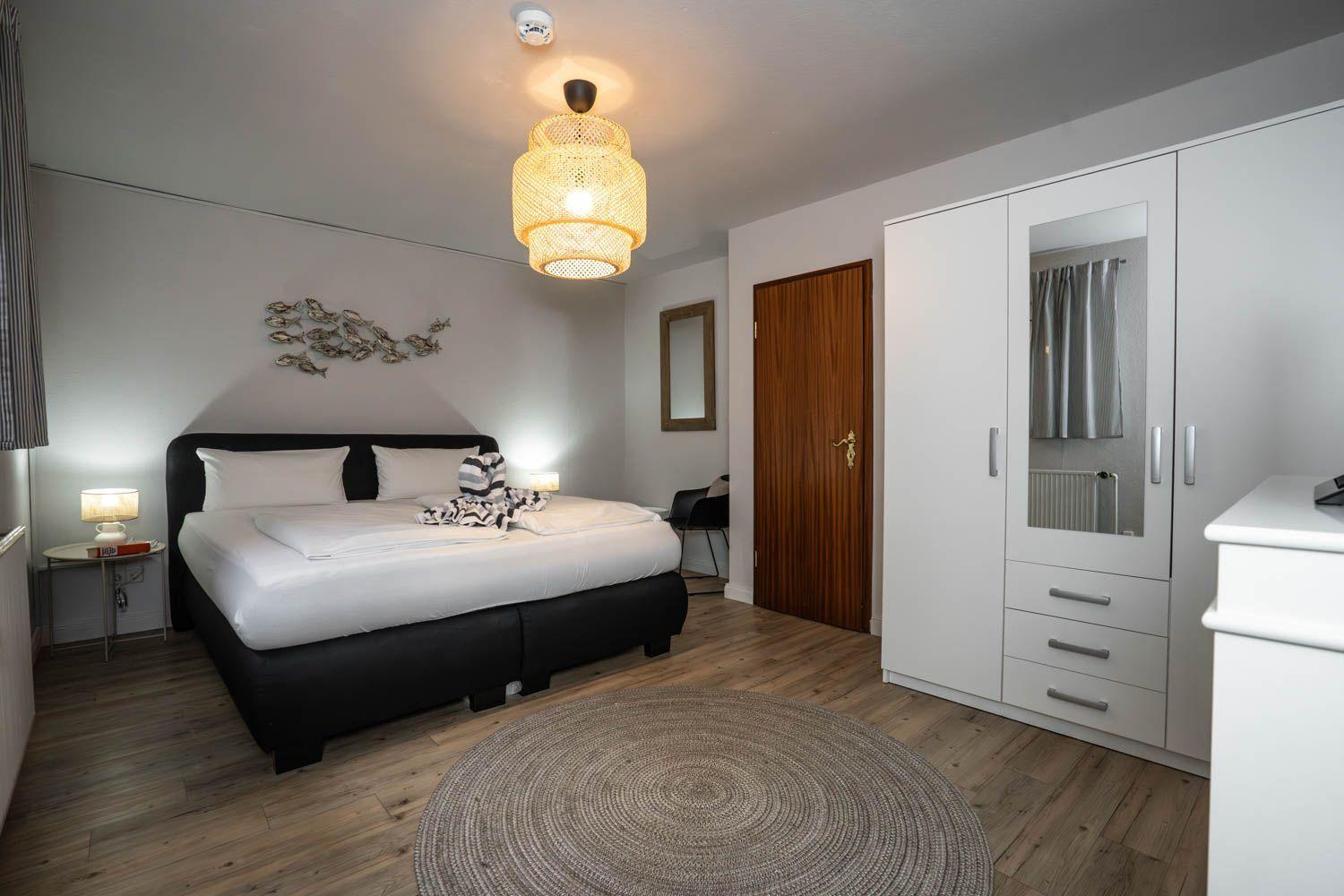 Schlafzimmer mit Doppelbett, Kleiderschrank und Deckenventilator.