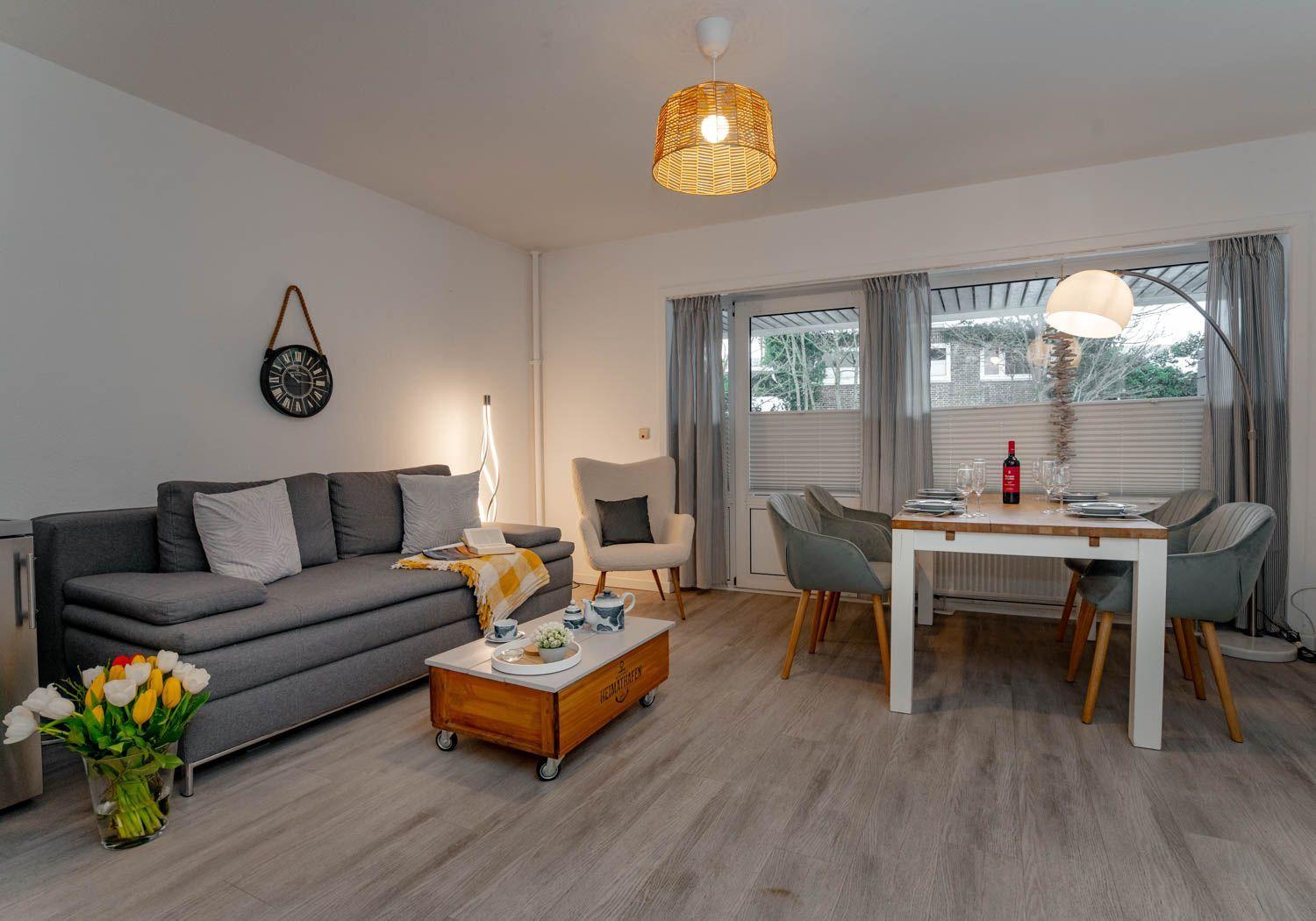 Wohn- und Essbereich mit Sofa, Esstisch und Fenster.