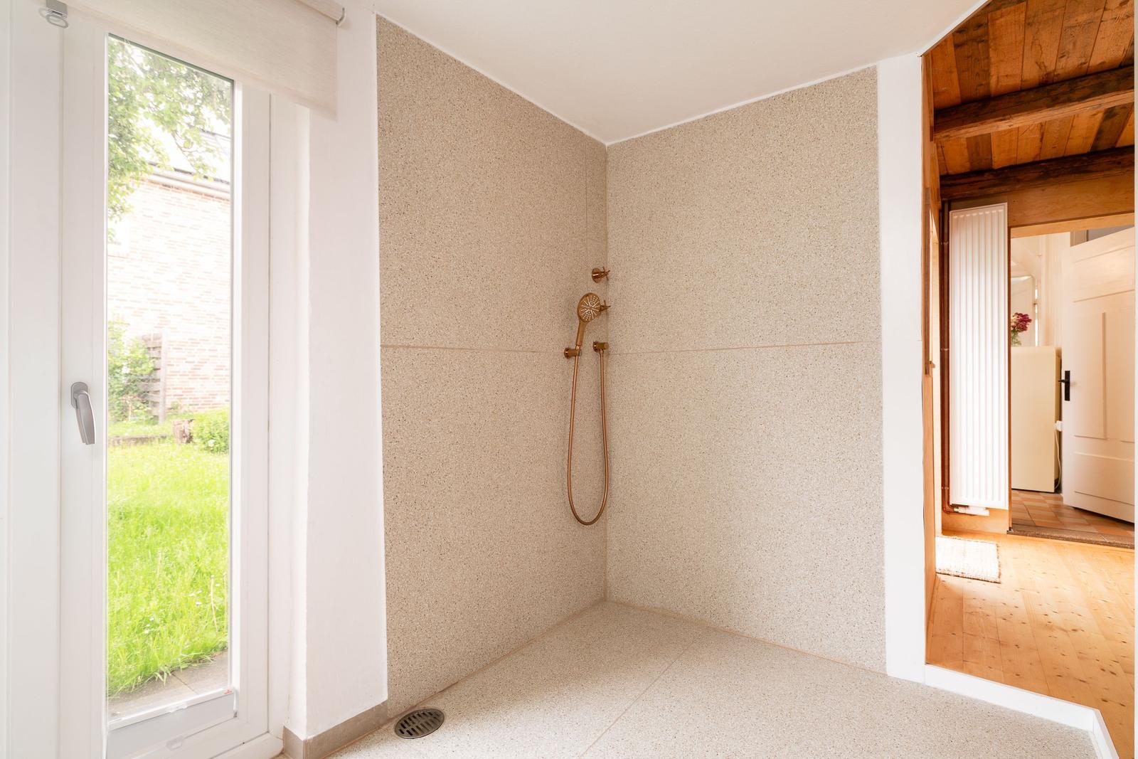 Dusche mit bodenebener Abfluss und Fenster zur Außenseite
