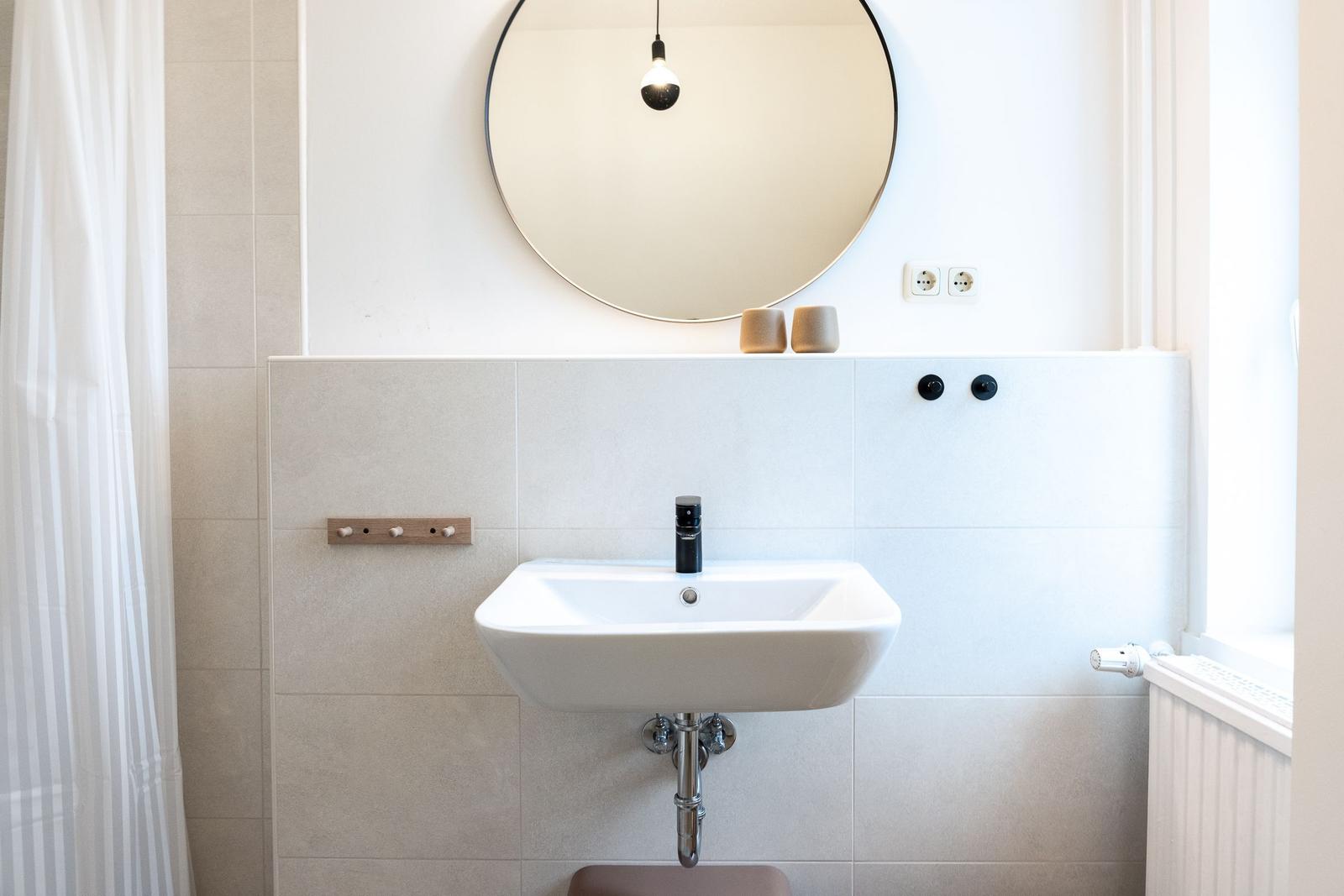 Waschbecken mit Spiegel und Dusche