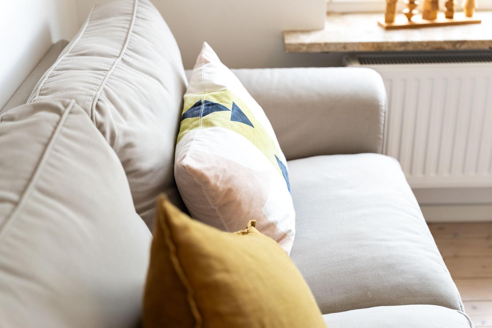 Ein Sofa mit Kissen in verschiedenen Farben und Mustern.