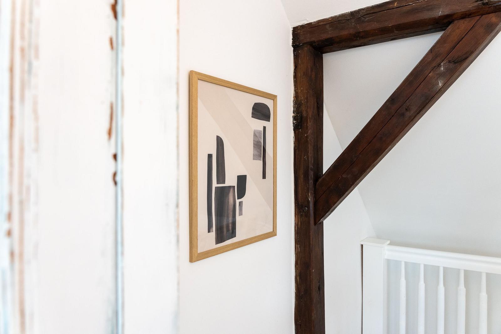 Wand mit Holzrahmen, Bild und weiße Treppe