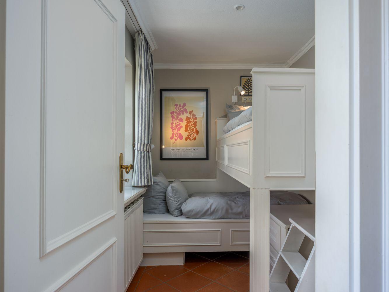 Schlafzimmer mit Doppelbett und unterem Bett, Wandbild und Fenster mit Vorhang.