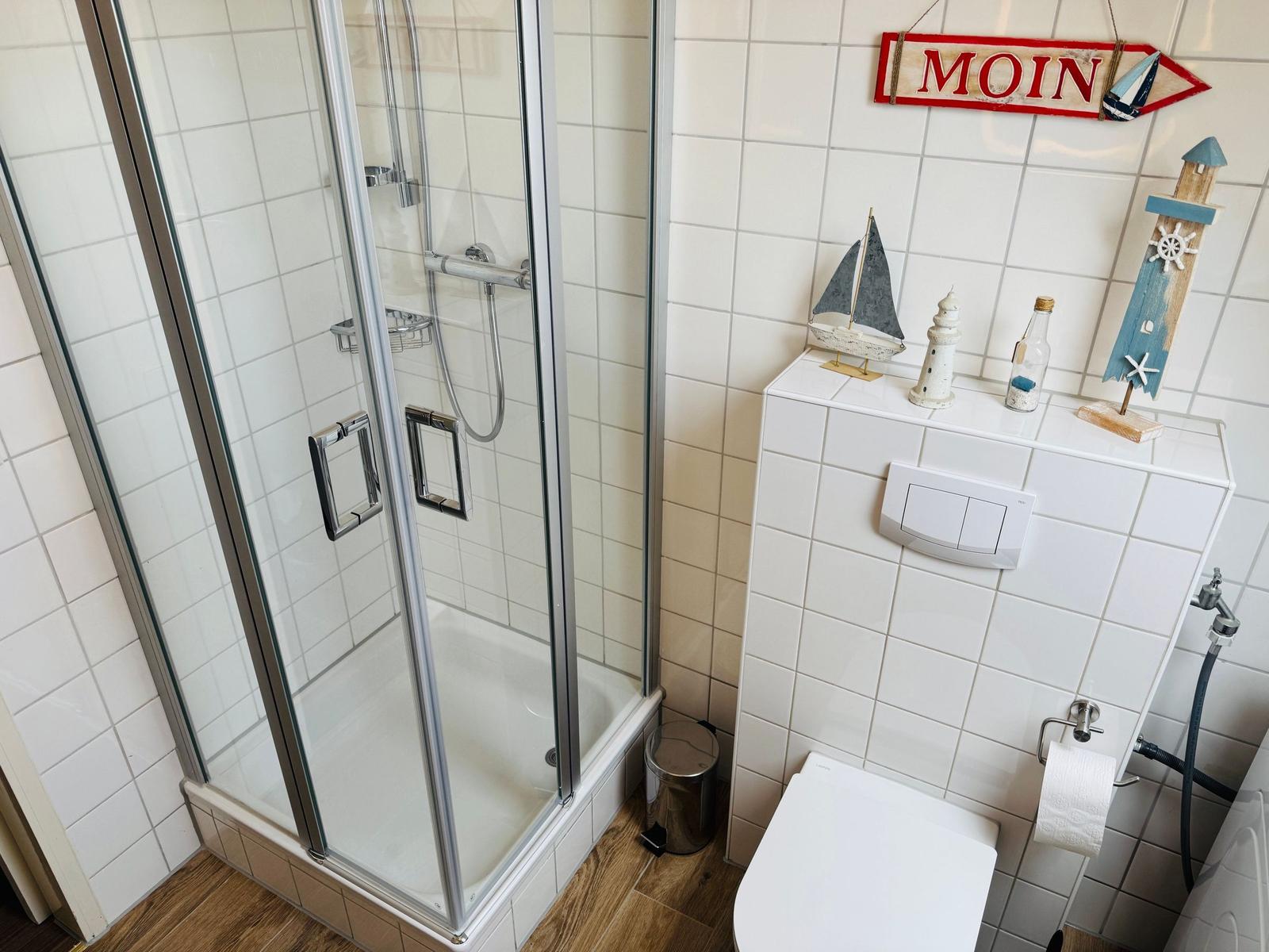 Bad mit Dusche, Toilette und maritimen Dekorationen.