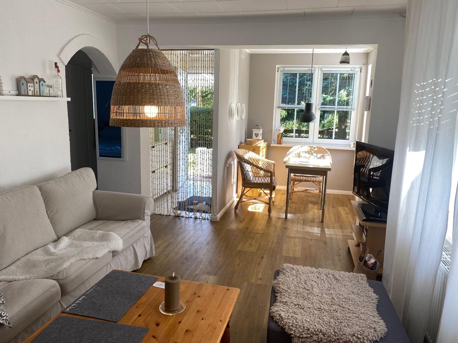 Living room with sofa, dining table, and window to terrace.