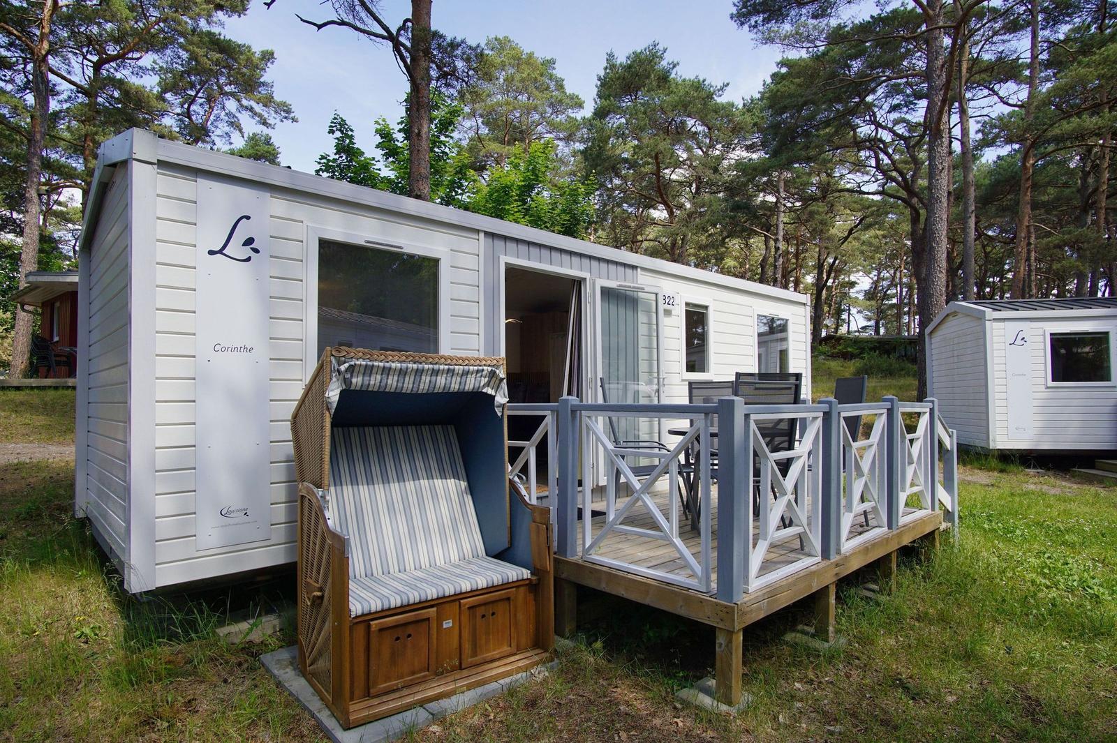 Wohnwagen mit Terrasse und Strandkorb in Waldnähe