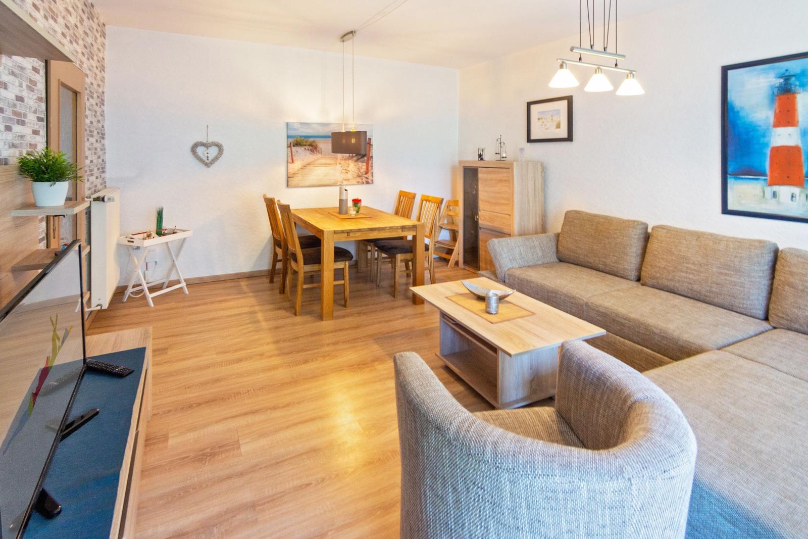 Wohn- und Essbereich mit Sofa, Esstisch und Holzboden.