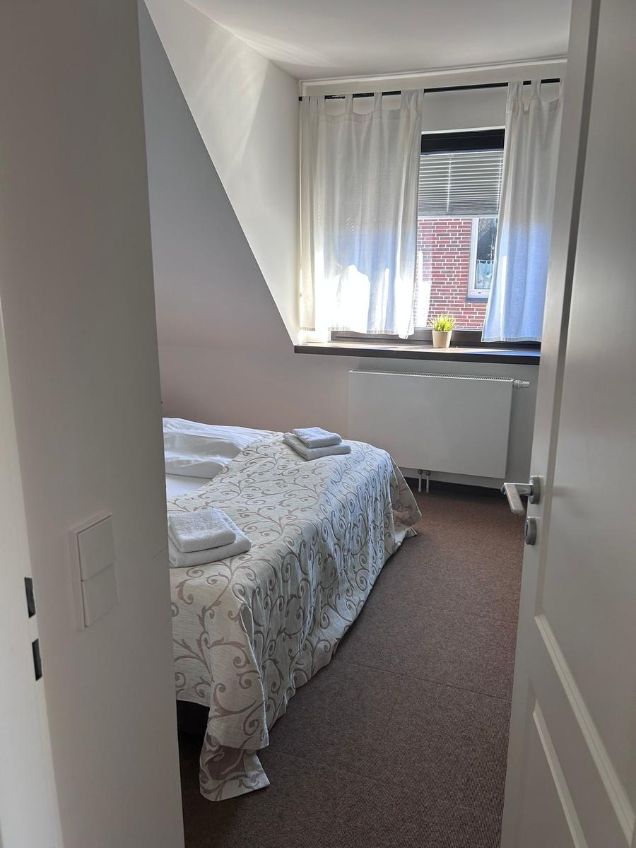 Schlafzimmer mit Bett, Fenster und Heizkörper