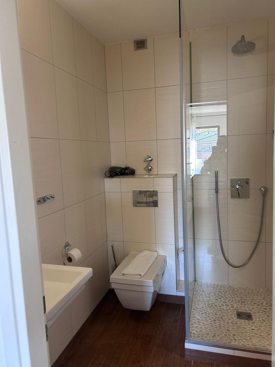 Badezimmer mit Dusche, Toilette und Waschbecken.