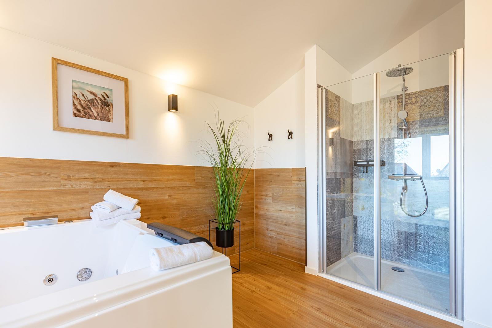 Bad mit Whirlpool und Dusche mit Glaswand.