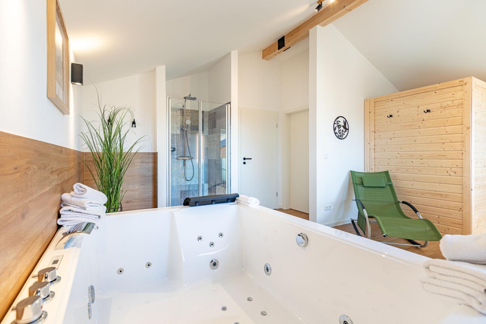 Bad mit Whirlpool, Dusche und grüner Liege