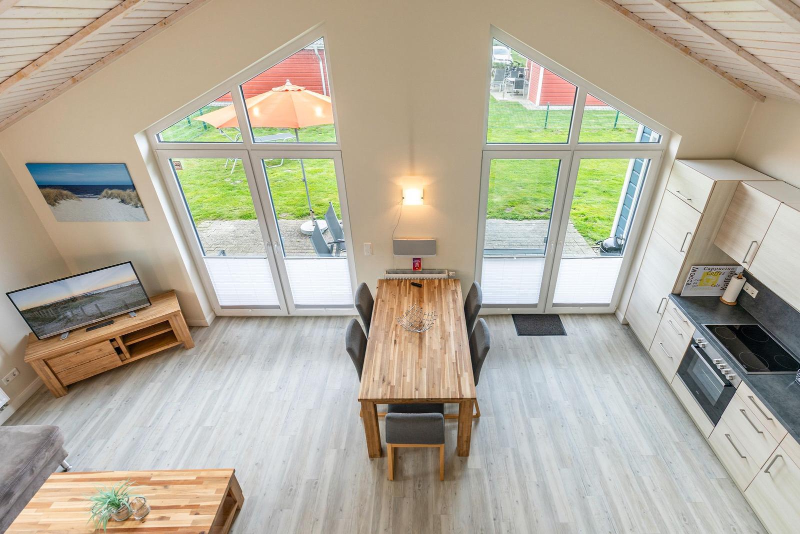 Großes Wohn- und Esszimmer mit Blick auf Garten und Terrasse.