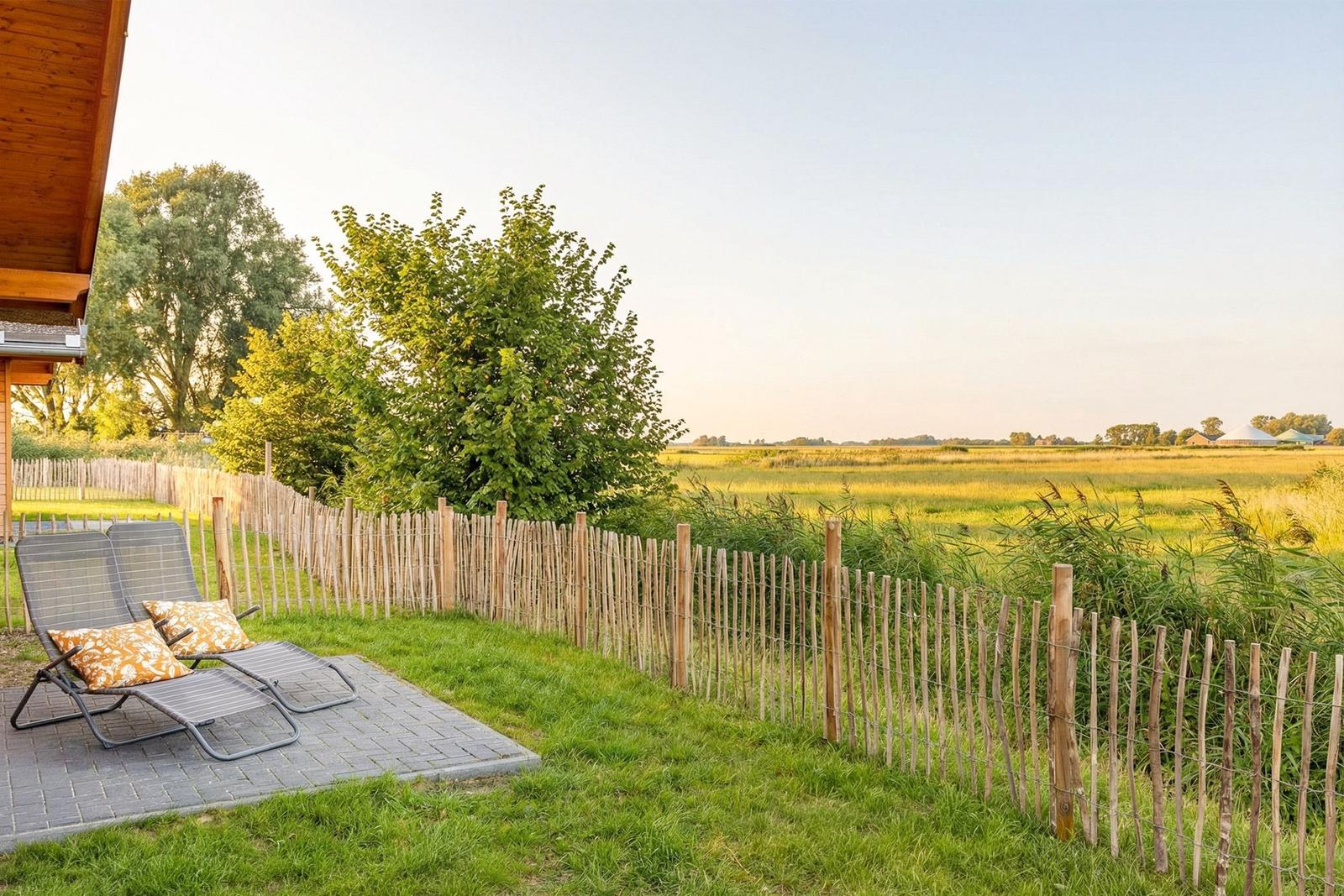 Terrasse mit Liegestühlen und Blick auf grünes Feld