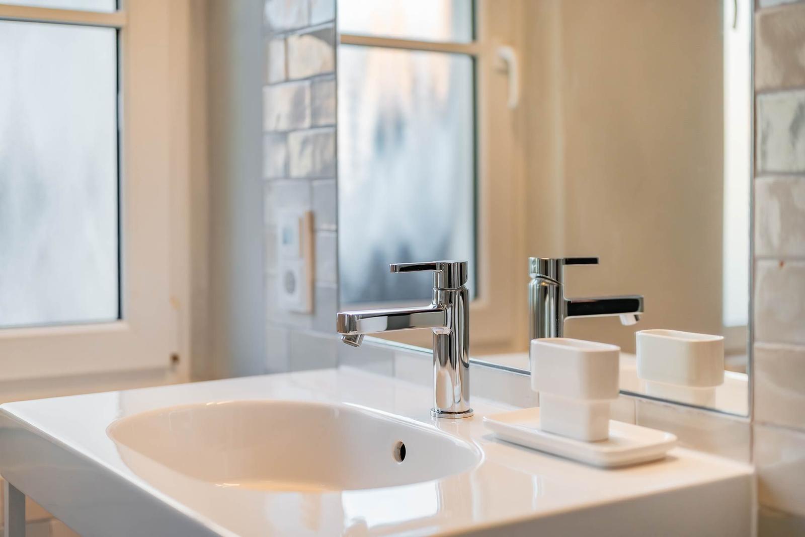 Waschbecken mit Wasserhahn und Spiegelschrank
