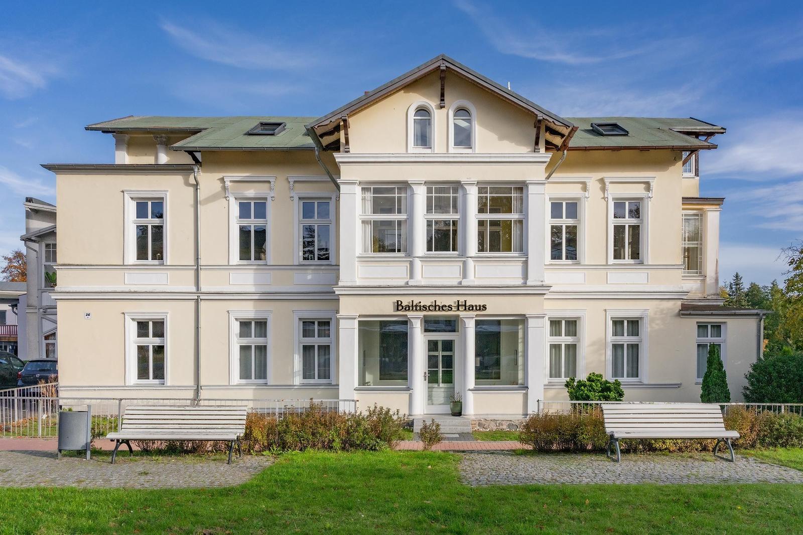 Baltisches Haus: großes, hellgelbes Gebäude mit weißen Fensterrahmen und Vorgarten.