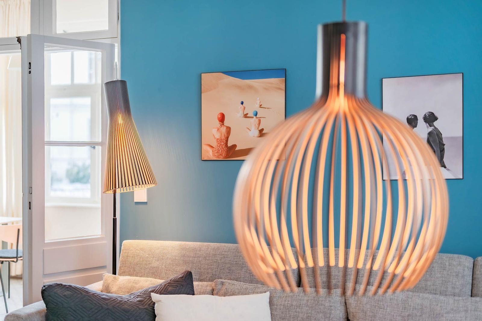 Ein Wohnzimmer mit blauen Wänden, einem Sofa und zwei Bildern an der Wand.