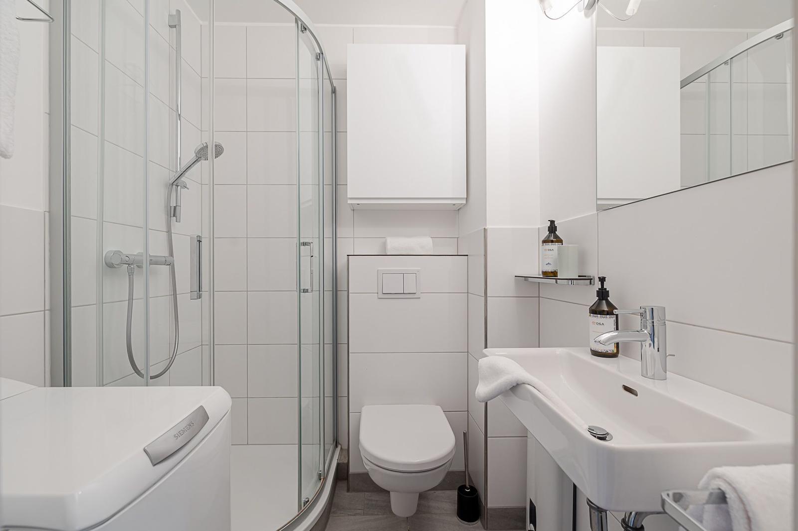 Badezimmer mit Dusche, Toilette und Waschbecken