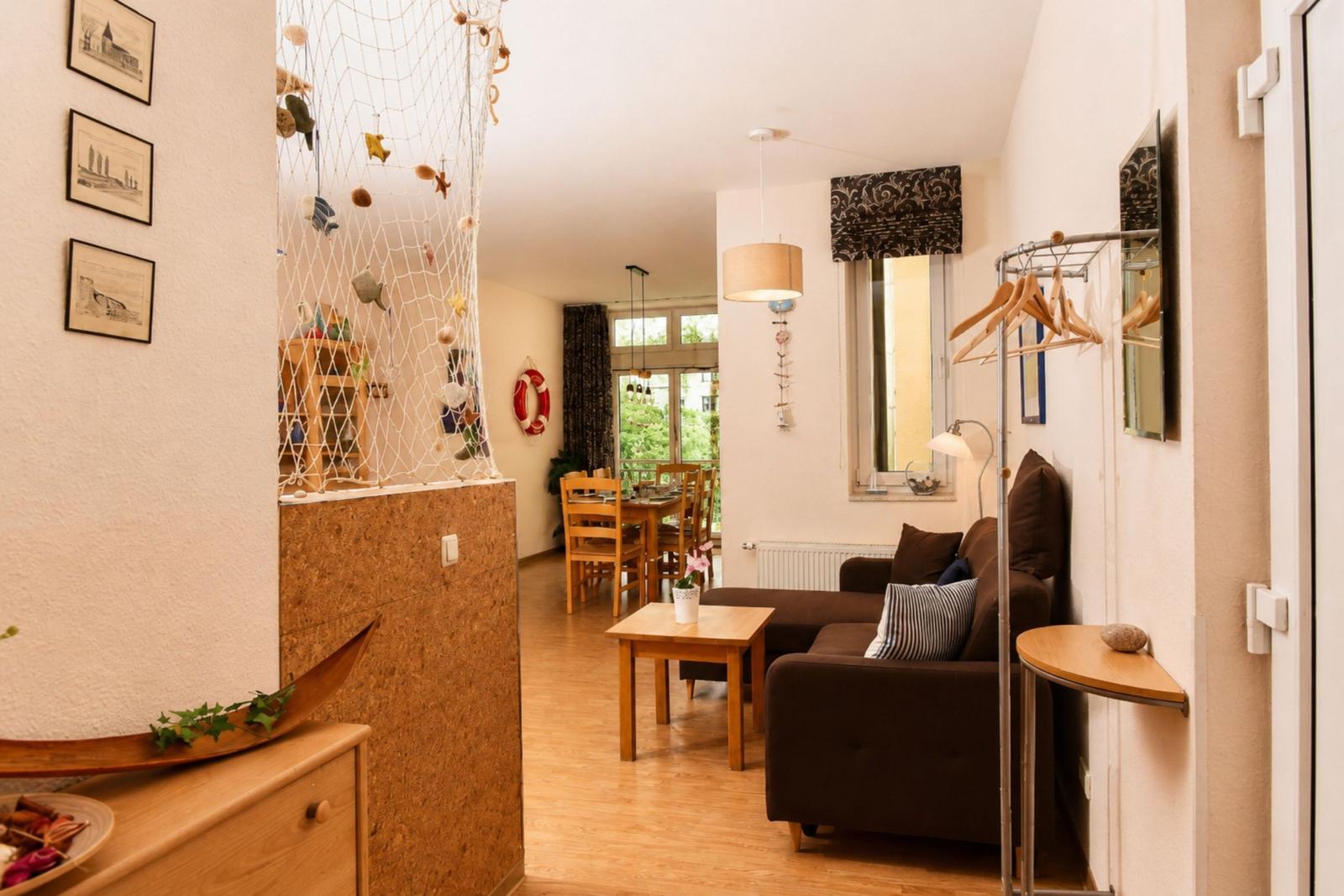 Wohnbereich mit Sofa, Tisch und Blick in die Küche.