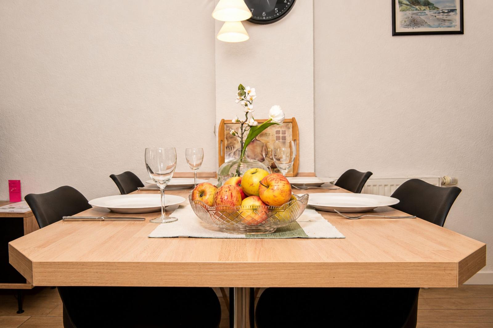 Esstisch mit Stühlen, Obstschale und Tischdekoration.