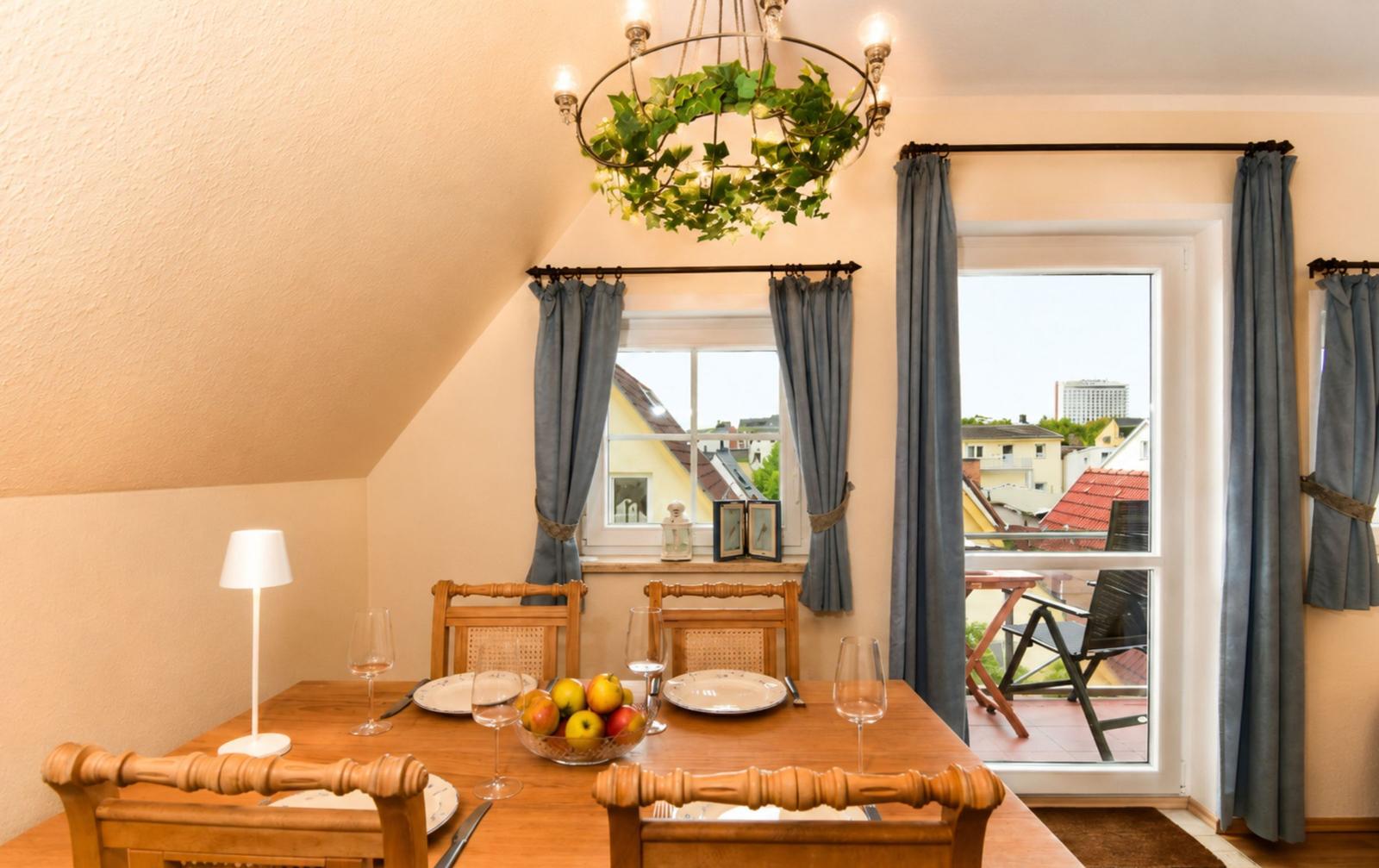 Esszimmer mit Holztisch, Stühlen und Blick auf Balkon
