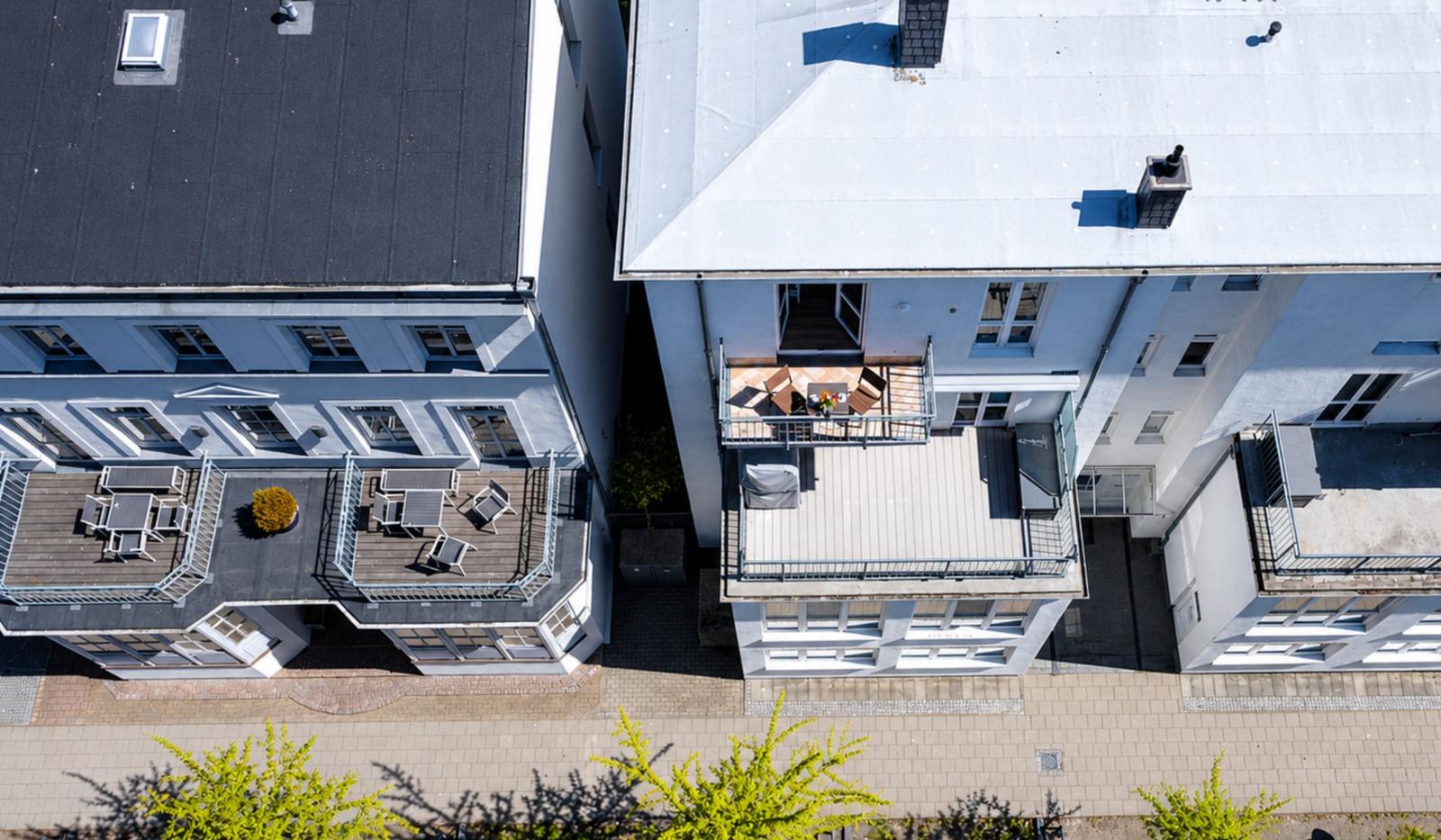 Roof terrace with table and chairs, adjacent buildings with balconies.