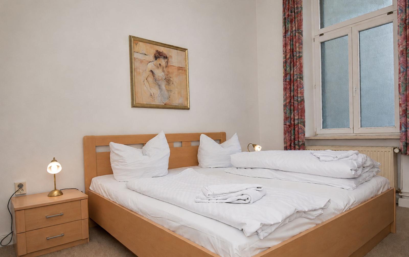 Ein Schlafzimmer mit einem Bett, Nachttisch und Bild an der Wand.