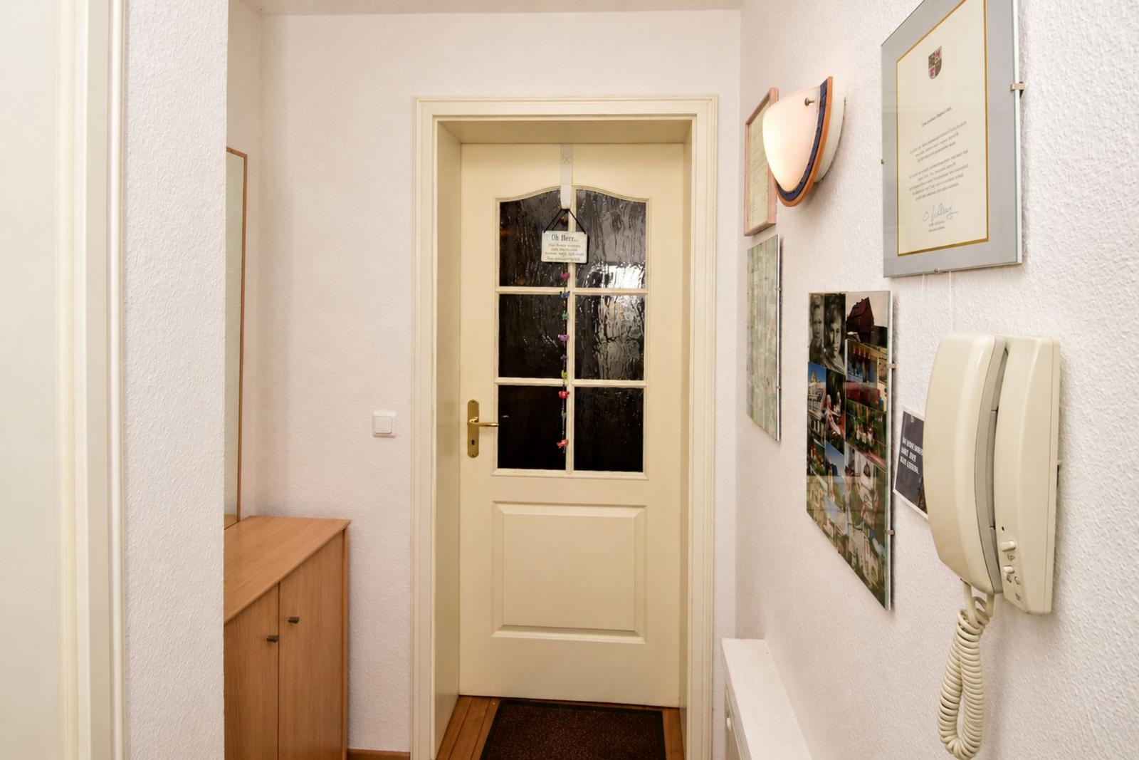 Entrance area with door, wall phone, and pictures on the wall.
