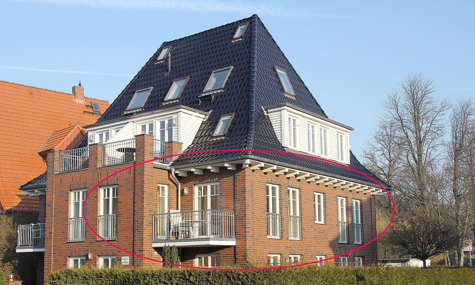 Ferienhaus mit rotem Backstein und dunklem Dach mit Dachfenstern.