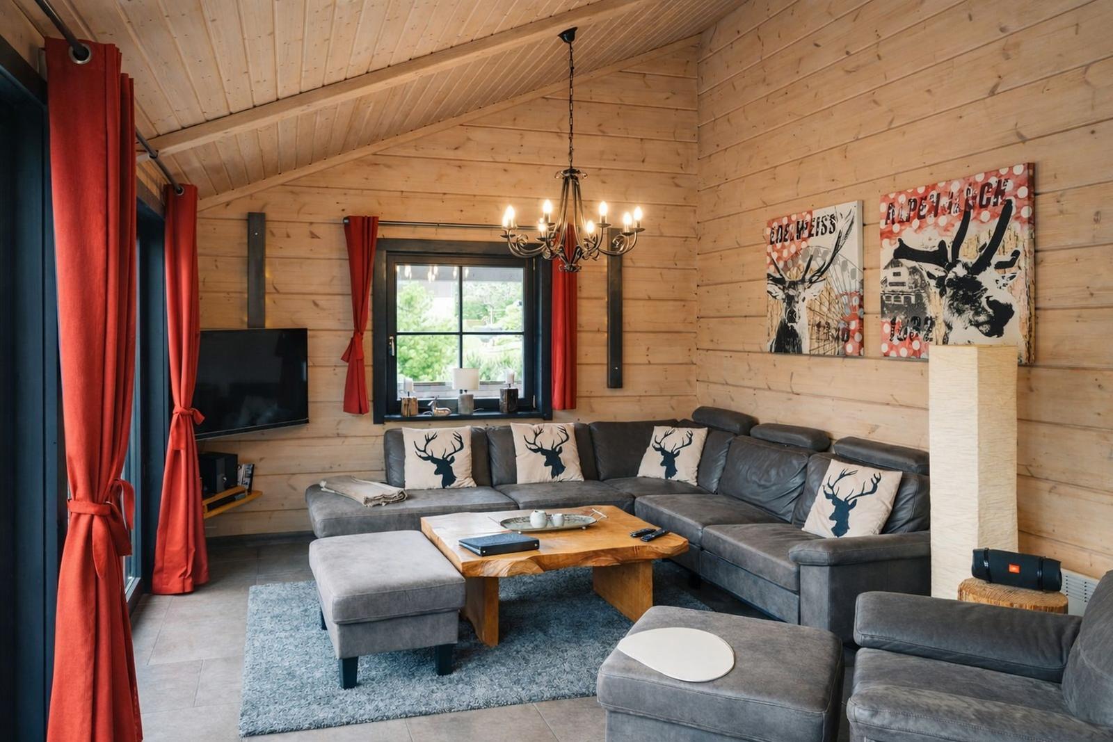 Wohnzimmer mit Holzwand, Sofa, Couchtisch und Fenster