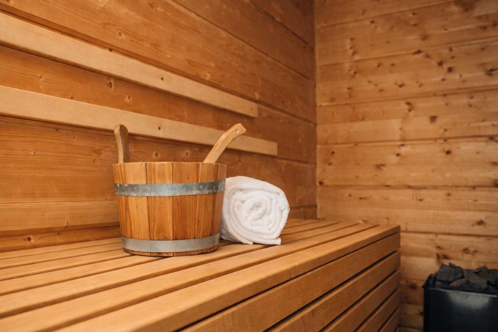 Sauna mit Holzbank, Eimer und Handtuch