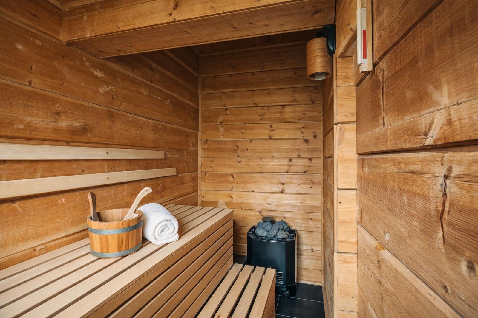 Sauna mit Holzbank, Eimer und Heizung