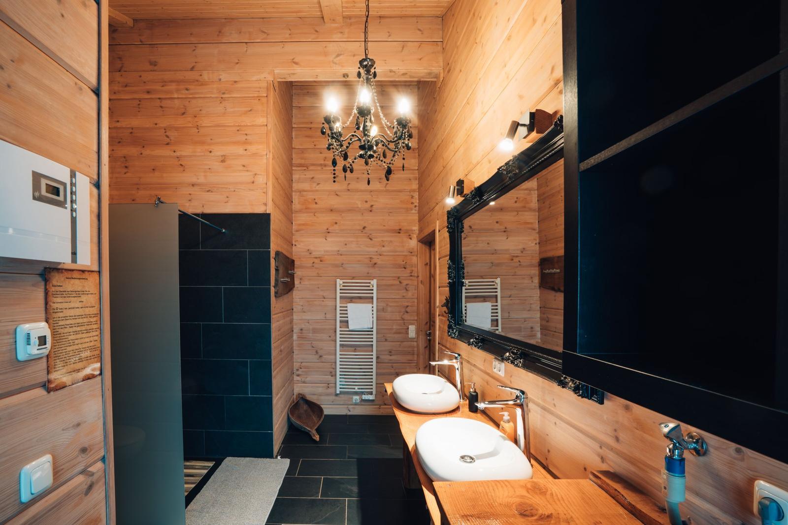 Bad mit Holzwand, Dusche, Waschbecken und Spiegel