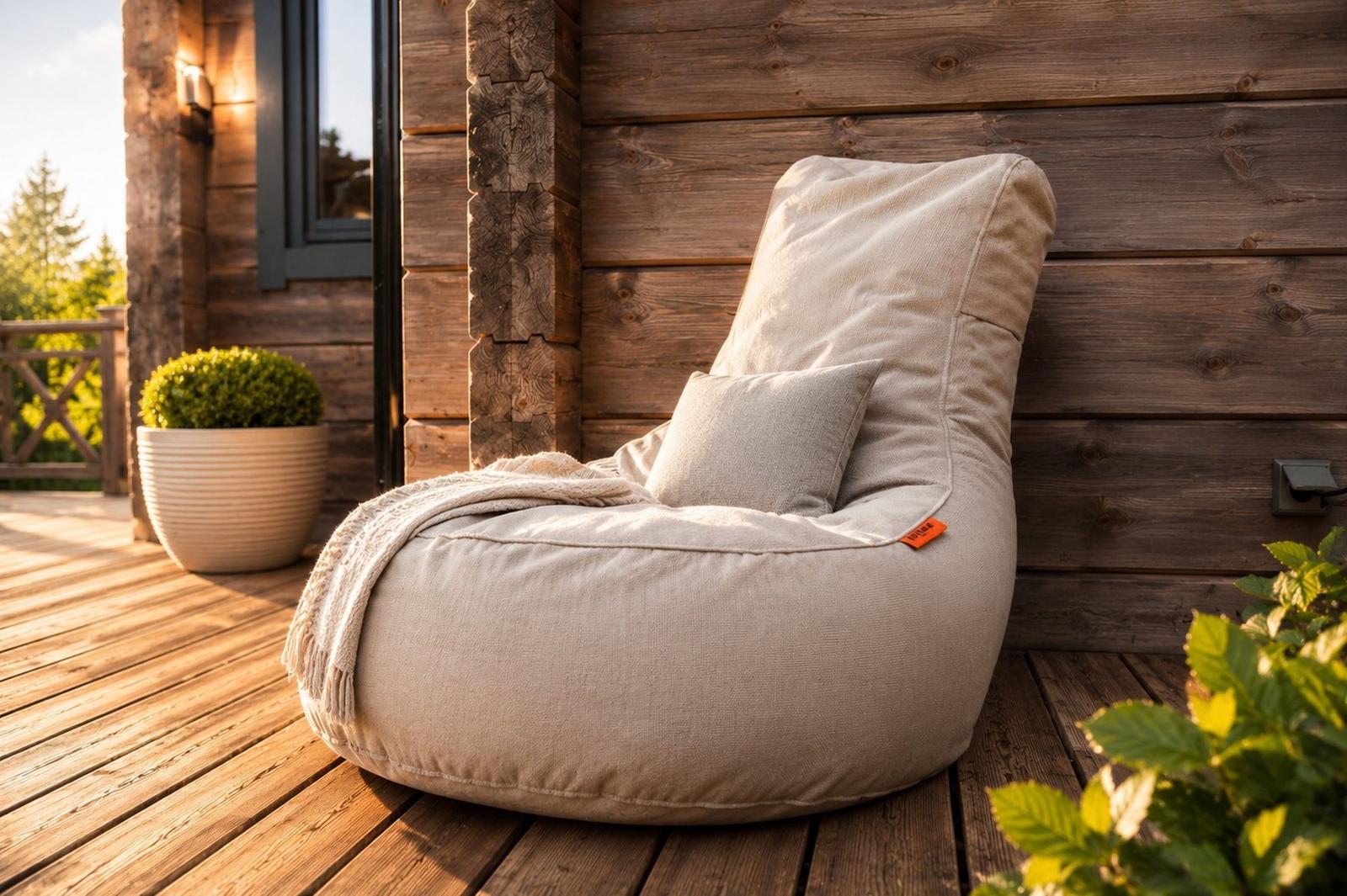 Beanbag-Stuhl auf Holzterrasse vor Holzwand mit Pflanzen und Decke.
