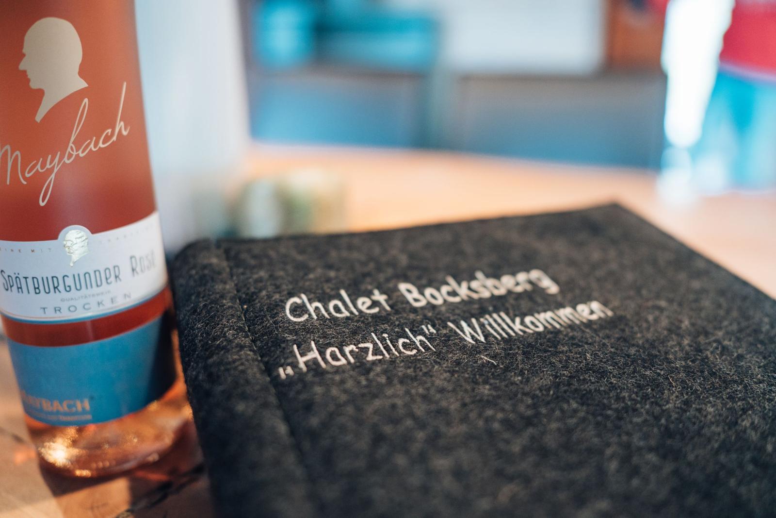 Willkommen im Chalet Bocksberg. Ein Glas Wein und ein Wollkissen mit Willkommensgruß.