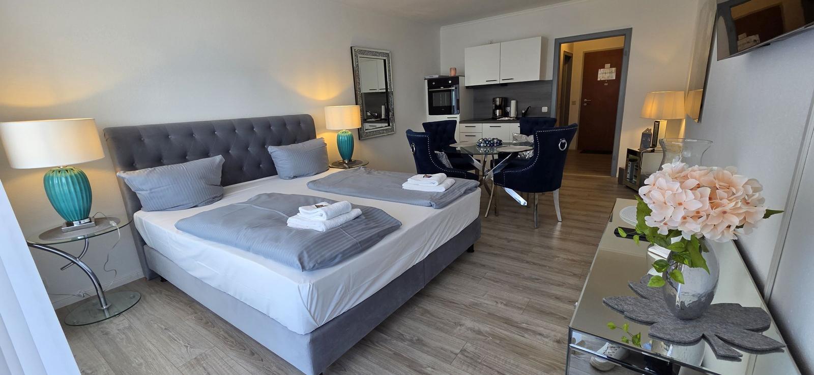 Schlafzimmer mit Doppelbett, Schlafzimmer mit Küchenbereich und Esstisch